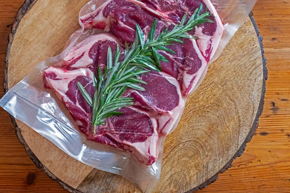 Auf dem Bild sieht man Fleisch mit Rosmarin einvakuumiert.