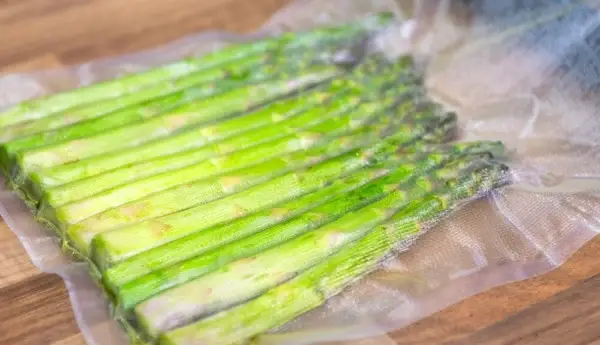 Grüner Spargel welcher in einem strukturierten Vakuumbeutel vakuumiert wurde.